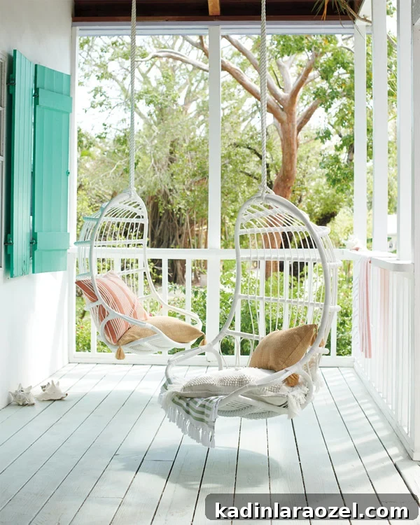 white hanging chairs on front porch of beach cottage