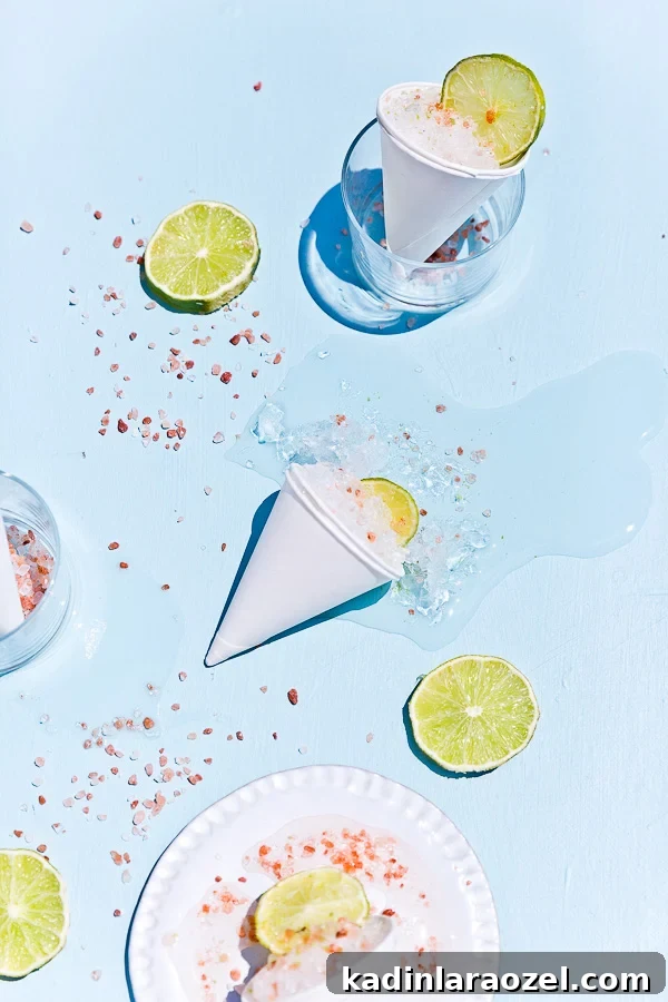 Cone Head Margarita Snow Cones: Frozen Cocktail Shaved Ice 4 melting snow cones on blue background with fresh lime slices