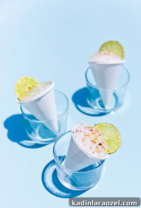 Cone Head Margarita Snow Cones: Frozen Cocktail Shaved Ice 7 Summer cocktail idea... Margarita Snow Cones closeup on clue background with lime slices