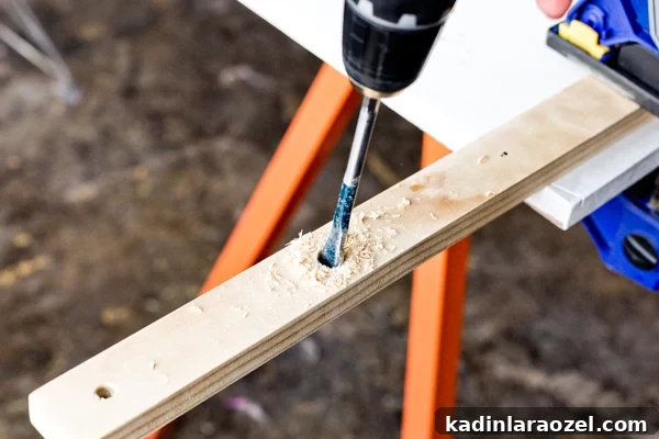 How to make a minimal wall hanging DIY that doubles as a plant holder. Start by drilling holes in the wood. #wallhanging #diyart #diywallart #diyplanter #diy #weekendproject
