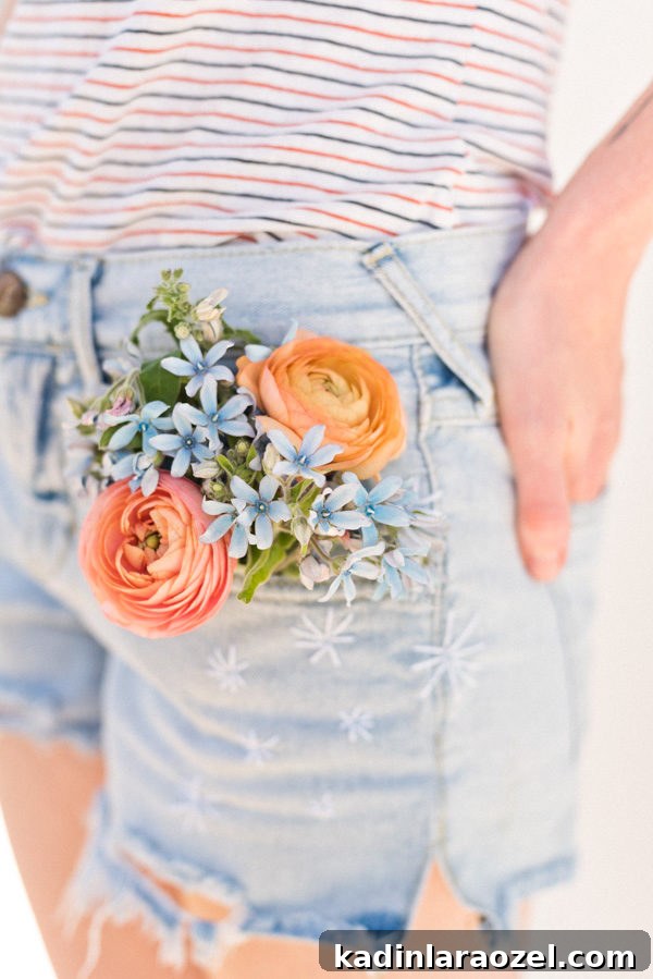 Detail image of embroidered jean shorts with flowers in jean pocket.