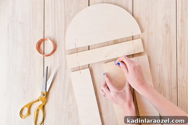 Assembling a wooden piece of wall art with copper wire