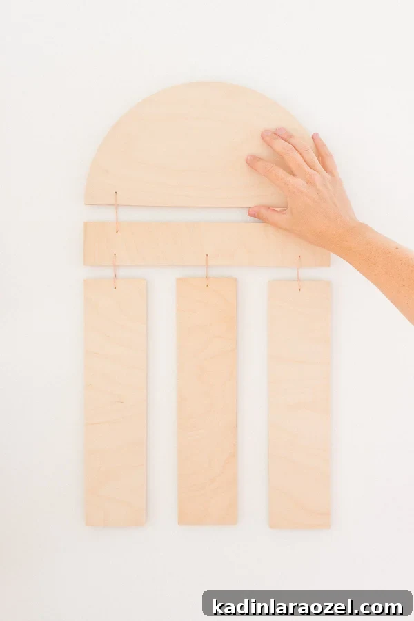 Hanging a geometric piece of wall art, made of wood, on the wall.