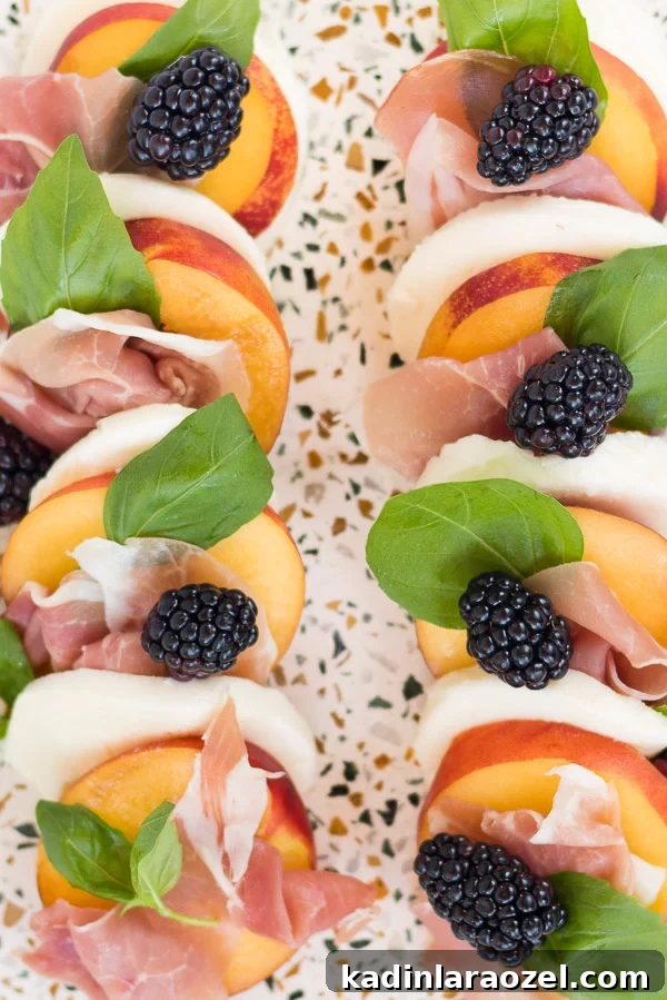 Closeup image of a peach and prosciutto caprese salad recipe with a blackberry balsamic reduction.