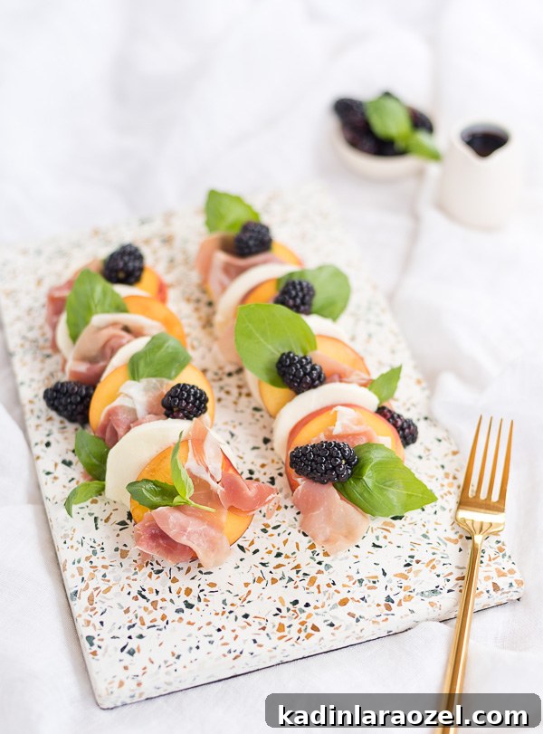 Peach and prosciutto caprese salad all lined up on a terrazzo tray.
