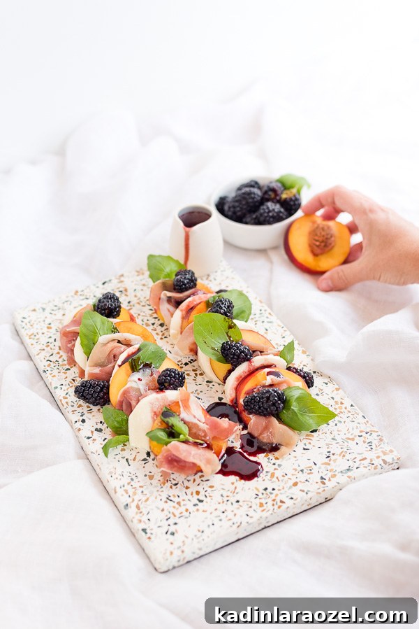 Image of peach and prosciutto caprese salad displayed on a terrazzo serving tray.