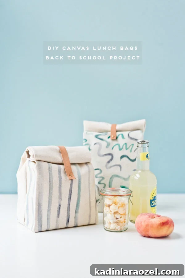 Two canvas lunch bags with simple designs, sitting on white table with fruit and a drink