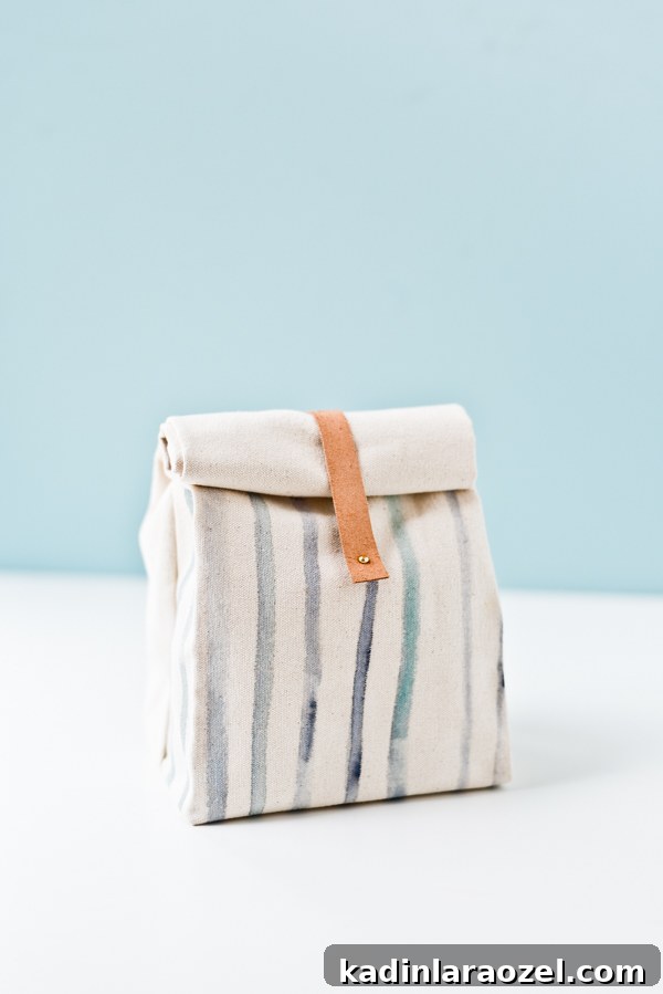 striped canvas lunch bag on white table with blue background 