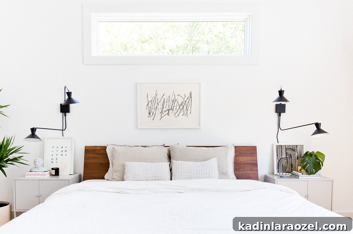 Minimal modern white bedding with walnut headboard and mid-century inspired sconces
