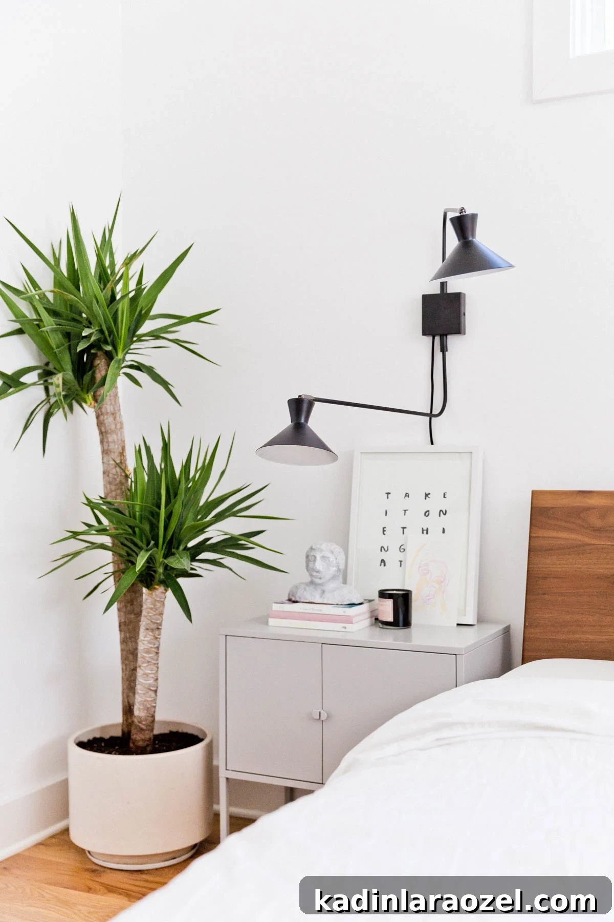 Minimal modern bedroom with plants, clean-line nightstand, and tall plants