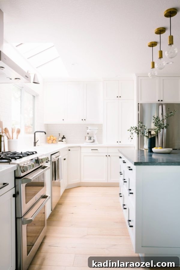 All white modern kitchen with minimal pendant lights hanging over the kitchen island