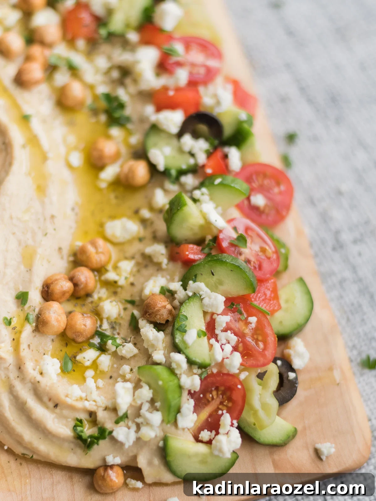 hummus board with greek salad toppings - cucumber, feta, tomato, garbanzo beans