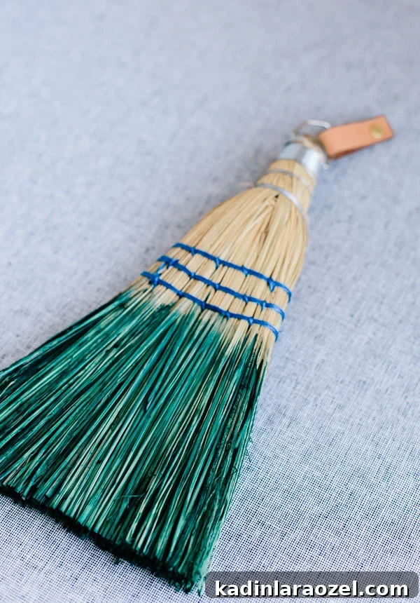 Dip dyed hand held broom in green