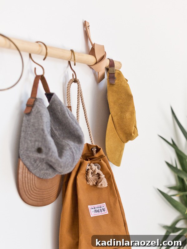 Hanging hats and brown backpack on wood rail with leather straps