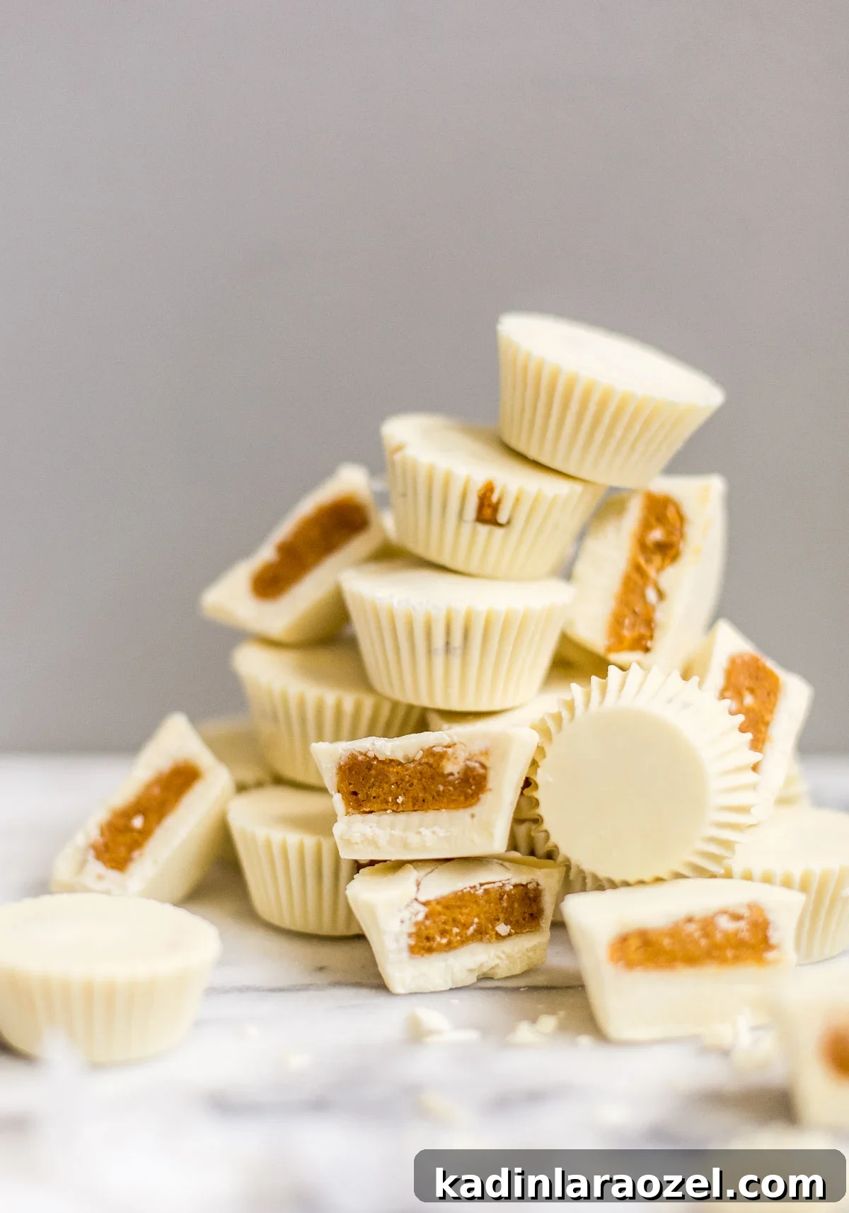 stacked pumpkin candy cups on a marble counter