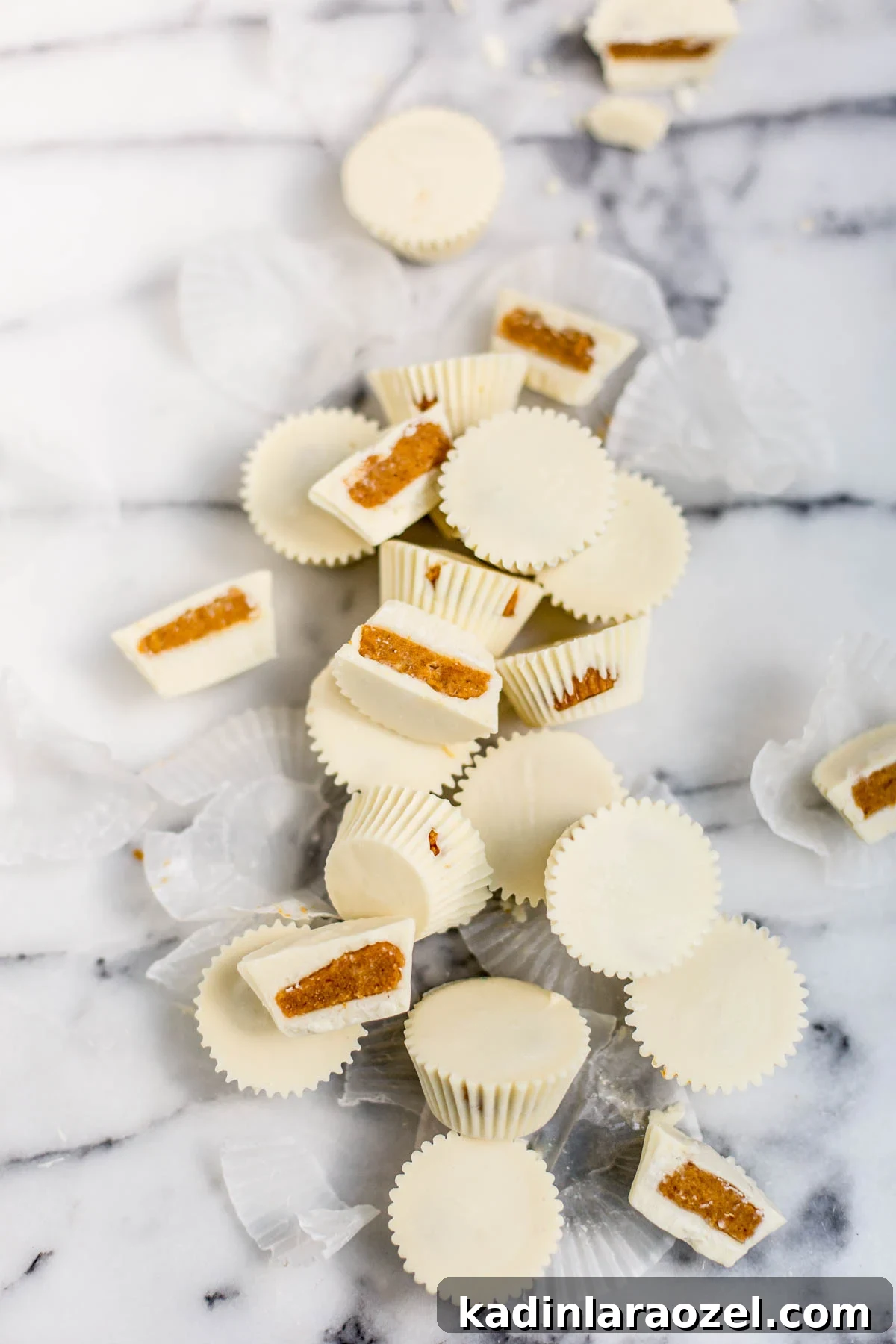 pumpkin pie candy cups with white chocolate laid out on a marble countertop