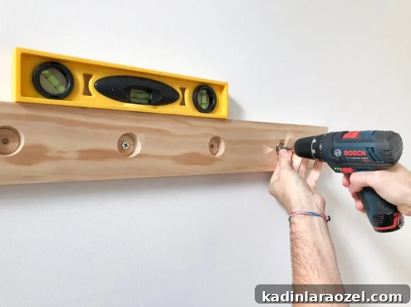 Totally Hooked: How to Make a Wood DIY Peg Rail Organizer. Click through for the tutorial. #woodproject #wooddiy #diyidea #diyproject #diywallhooks #wallorganizer