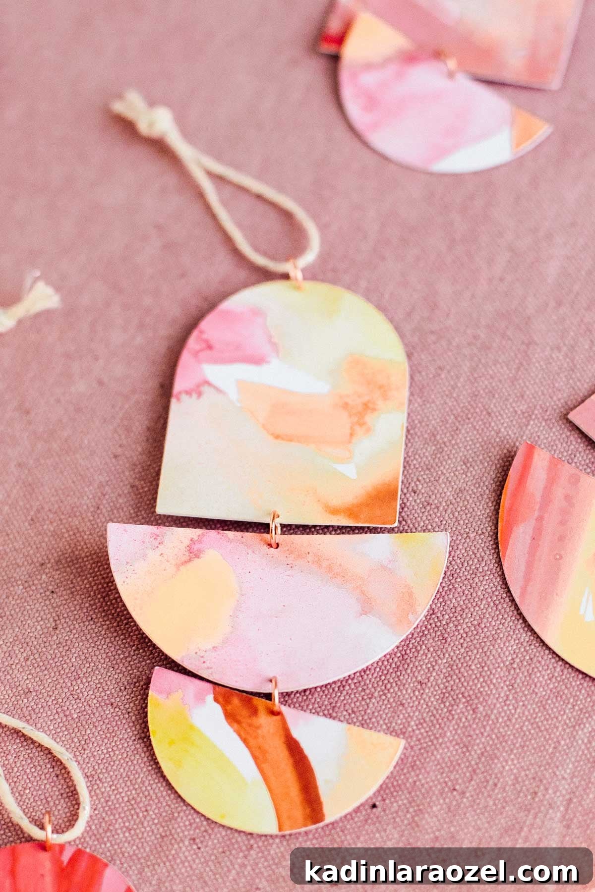 Closeup for geometric DIY ornaments made of painted paper, wire, and string