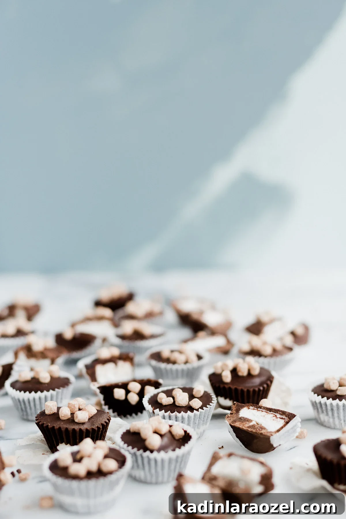 chocolate and marshmallow candy cups scattered on marble countertop