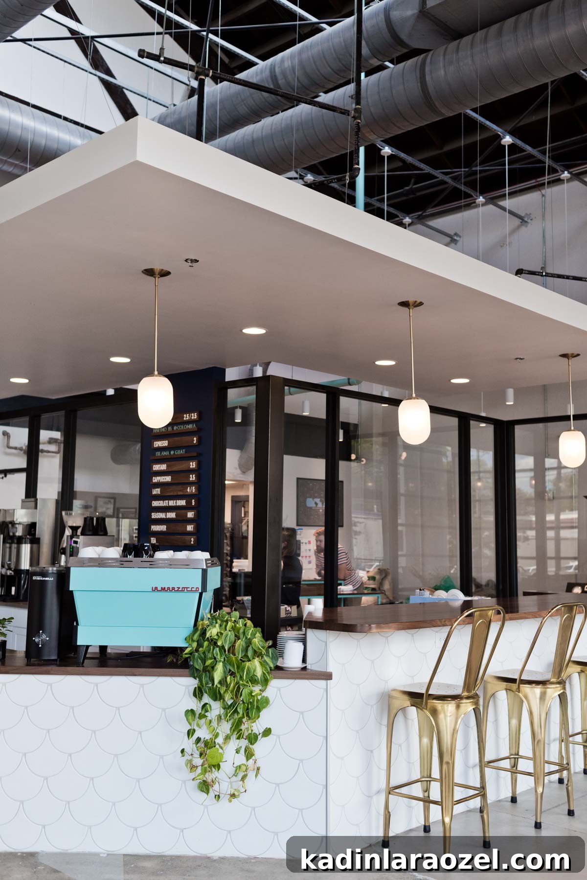 coffee shop in Atlanta with white tile and bright blue coffee maker with gold bar stools