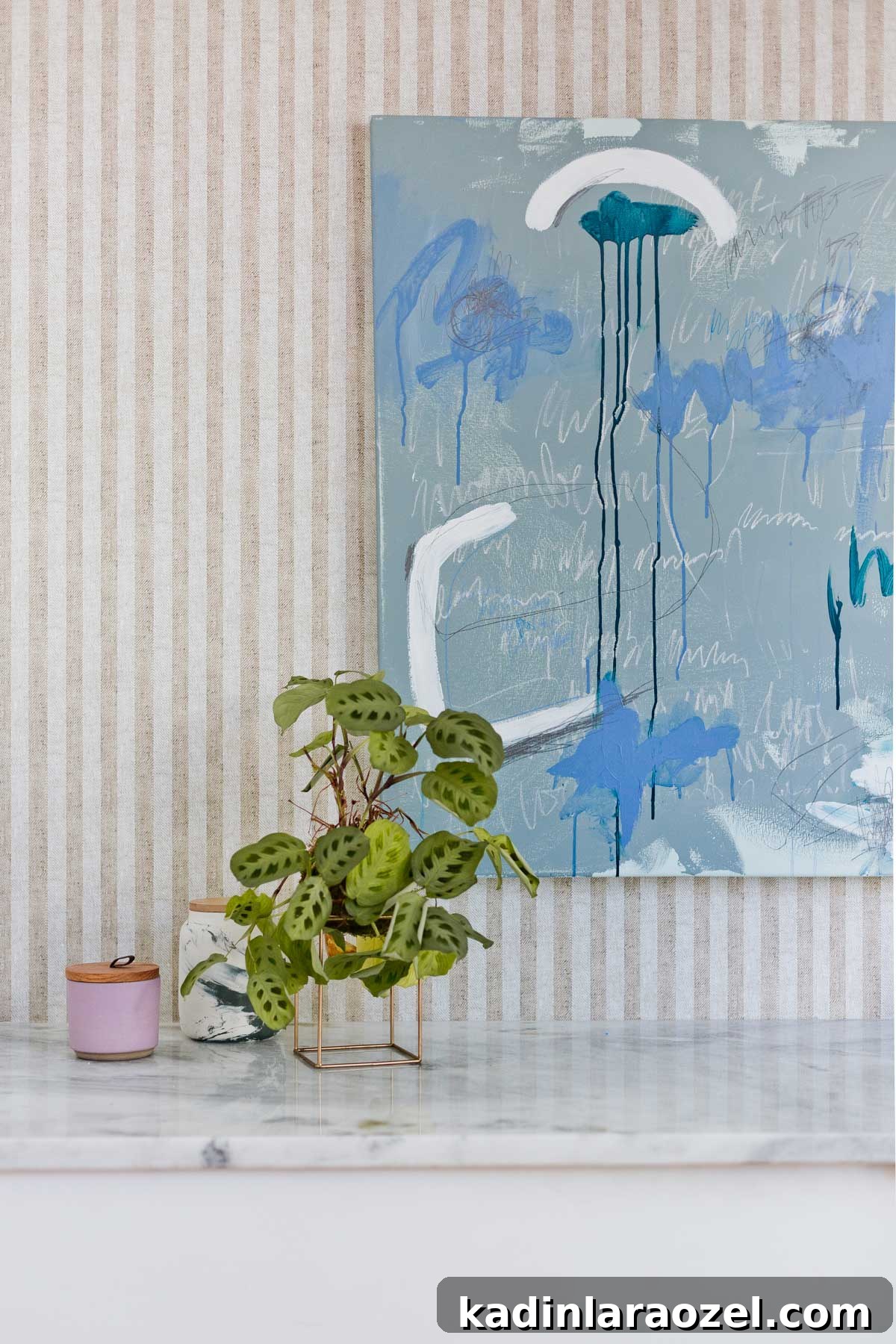 From Farmhouse Drab to Modern Chic: Transforming an Awkward Landing for Under $450 9 Striped wallpaper with abstract artwork and plants