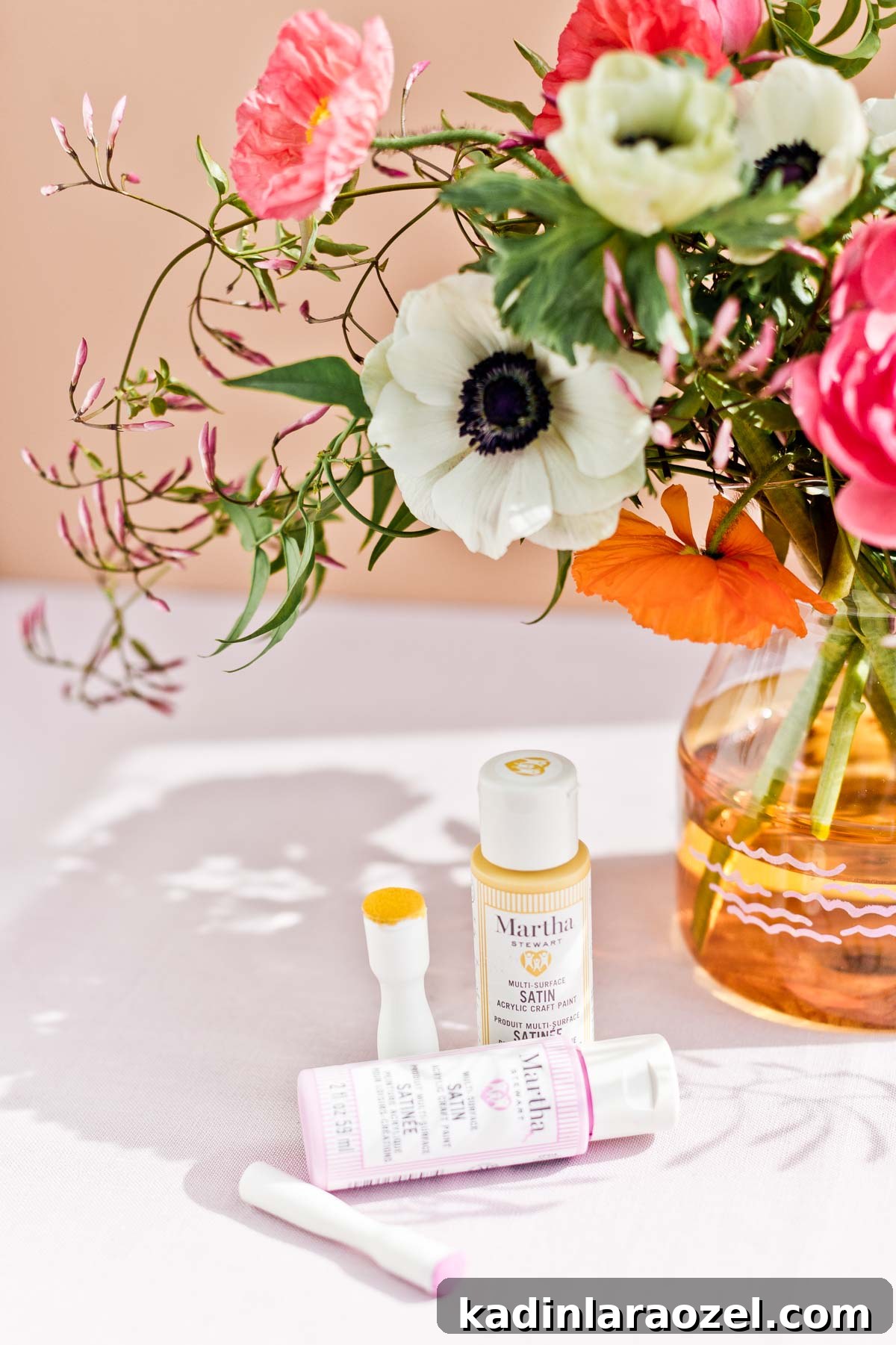 Orange glass vase with colorful fresh flowers and Martha Stewart paint materials