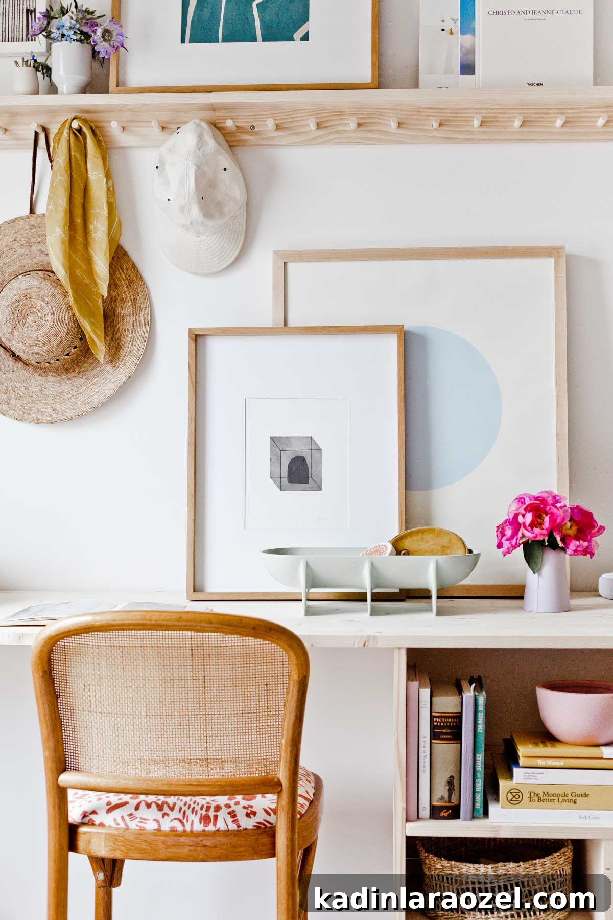 Wood desk with open shelving and artwork resting on the tabletop