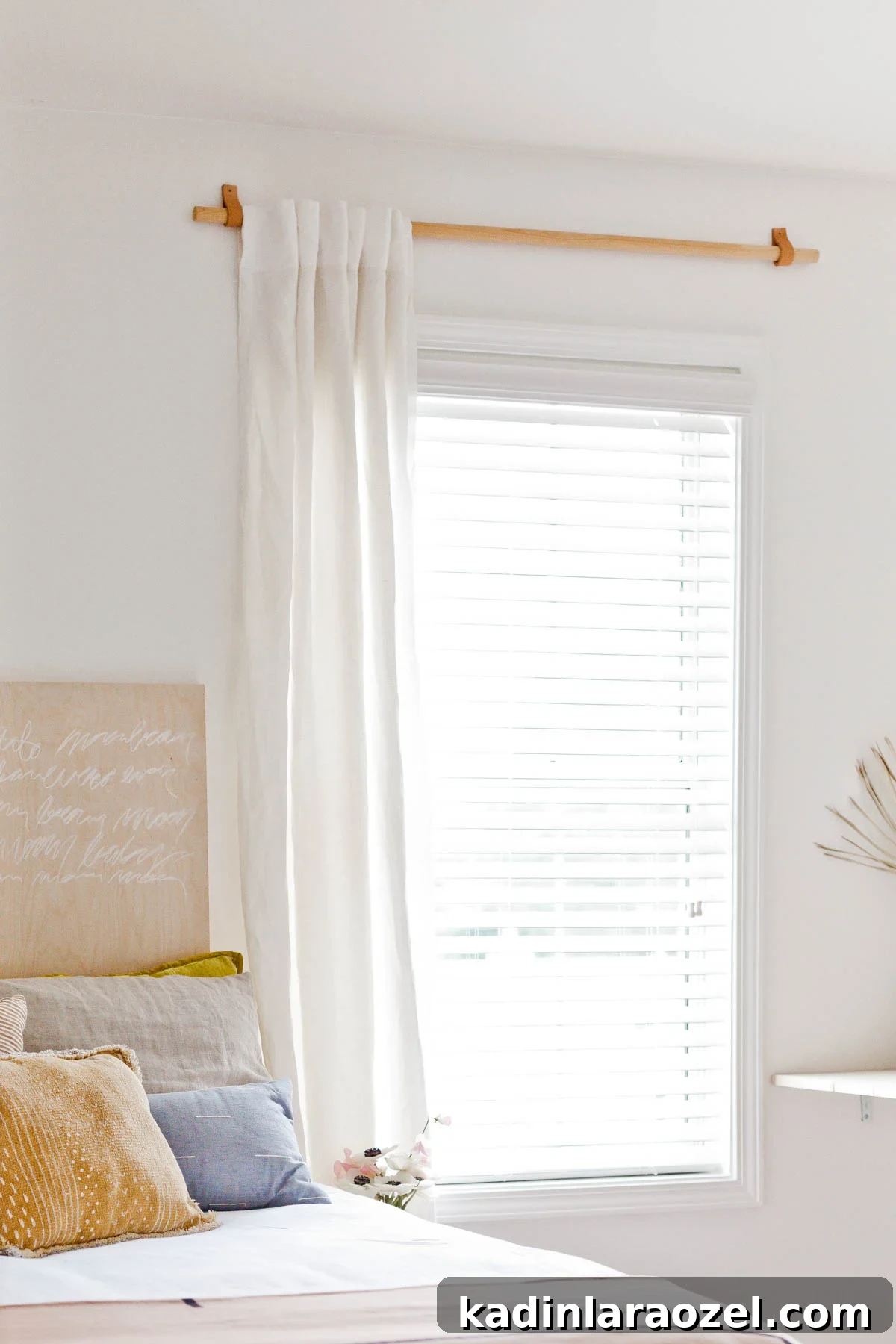 DIY Curtain Rods for Under $10: A Step-by-Step Guide 2 simple wood curtain rod with white curtains in a light and airy bedroom