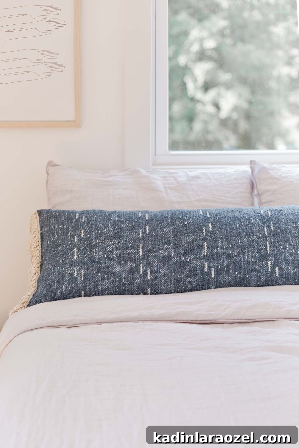 How to Sew an Extra-Long Lumbar Pillow for Sofa and Bed 11 Blue extra long lumbar pillow on neutral linen bedding in light-filled room.