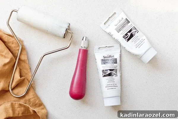 Block Printing Basics: A Step-by-Step Guide to Printing Fabric 4 Printmaking supplies, which include a carving tool, brayer, and block printing ink.