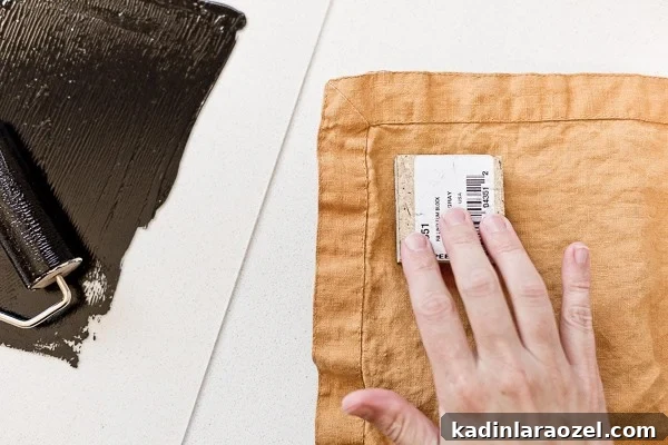 Block Printing Basics: A Step-by-Step Guide to Printing Fabric 9 Pressing carving linoleum block onto fabric to create a permanent pattern.