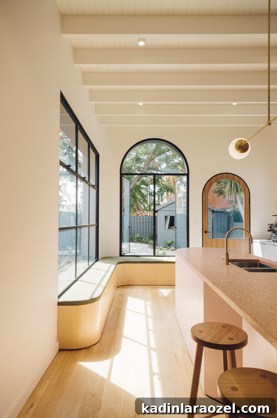 These arched windows and doors from Sans Arc Studio make this space feel extremely playful and elevated at the same time. I love the contrast of the dark window frame and mullions and the light wood door. #arch #designtrend #interiors #organicmodern #kitchen #archwindow #archdetail