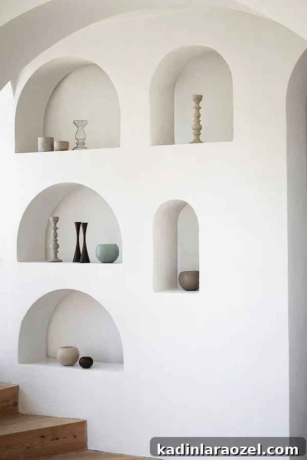 Function and fashion go hand in hand with these built in arched shelves from Apartment34. #arch #designtrend #interiors #organicmodern #livingroom #archbuiltin #builtins #shelving #archshelving