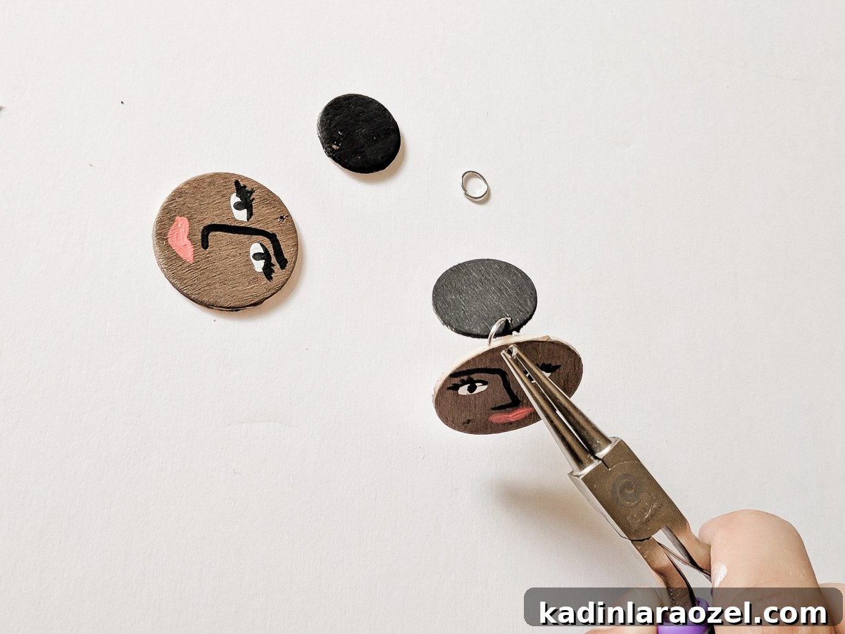 Add jump rings to connect the smaller circle to the larger face circle.