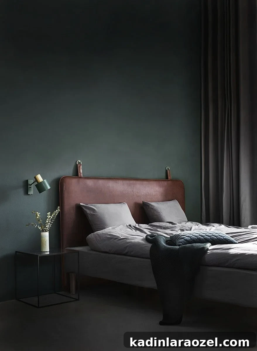 Moody Green Interiors: 12 Stylish Ways to Use the Color 3 A moody green bedroom with leather headboard and minimal modern decor.