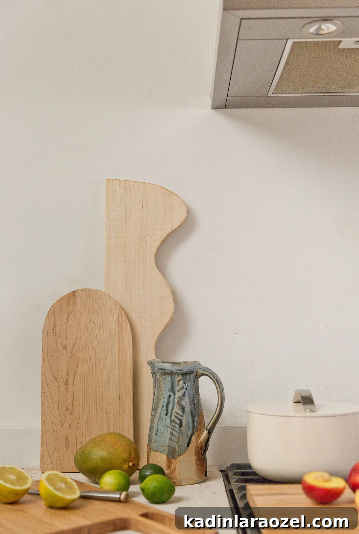 wood cutting boards on a minimal neutral countertop kitchen with citrus
