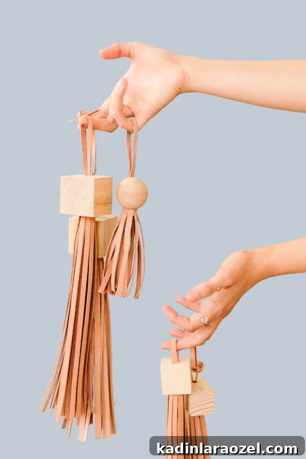 woman holding wood and leather diy tassels with blue background