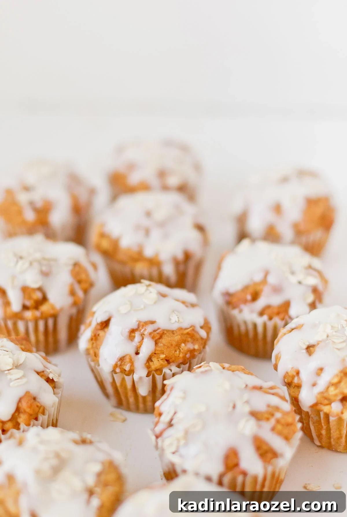 Simple Delicious Pumpkin Muffins Recipe You’ll Love 4 Pumpkin muffins with a cream cheese glaze and oats sprinkled on top.
