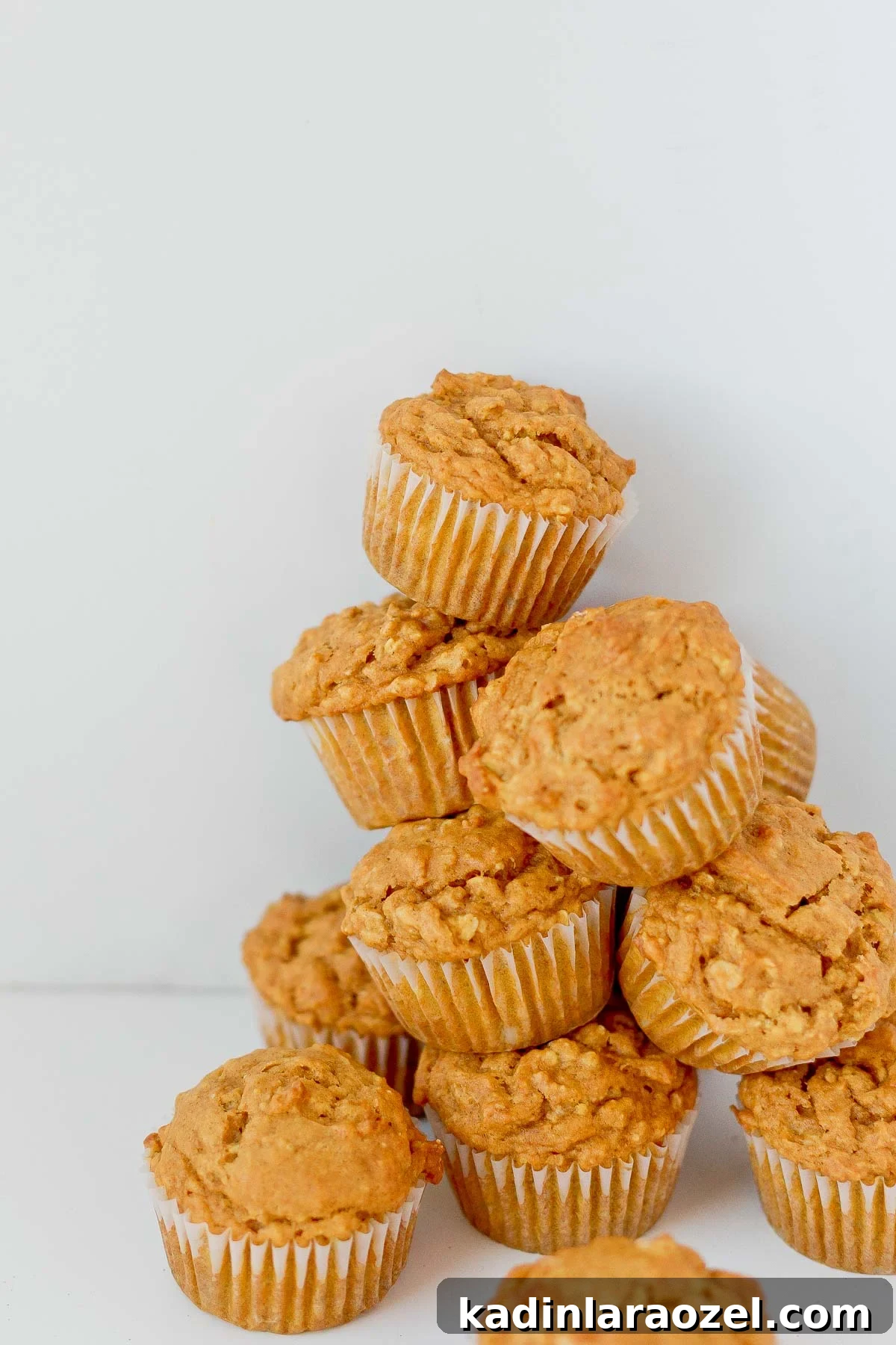 Simple Delicious Pumpkin Muffins Recipe You’ll Love 5 Pumpkin oat muffins stacked on top of each other.
