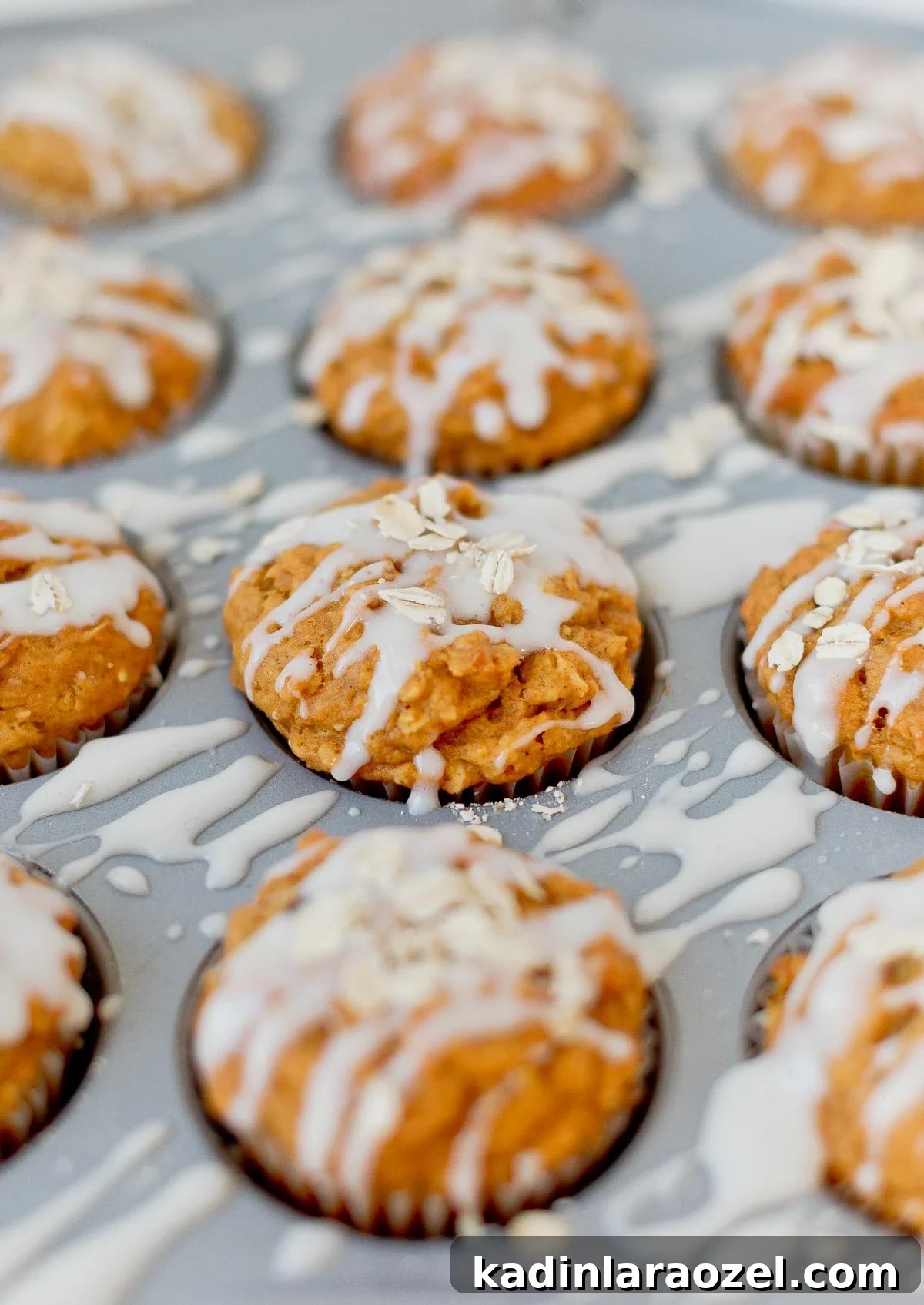 Simple Delicious Pumpkin Muffins Recipe You’ll Love 6 Pumpkin muffins with a drizzle of cream cheese glaze and oats sprinkled on top.