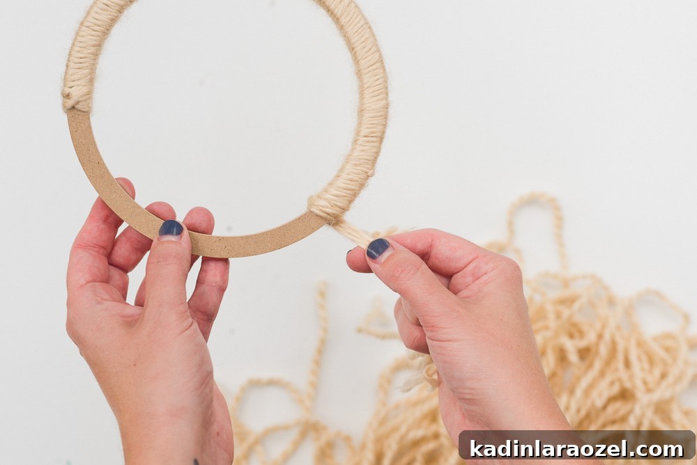 Wrapping yarn around a floral ring to make a fall wreath.