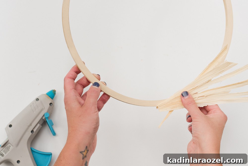 Attaching corn husks and grasses to a floral ring for a festive fall wreath.