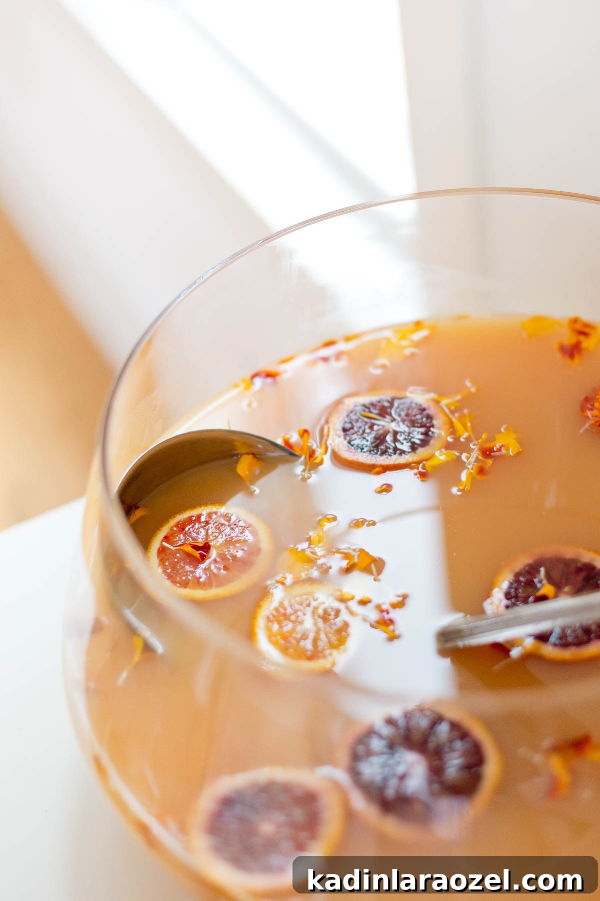 Holiday punch with blood orange and satsuma orange slices and edible flowers