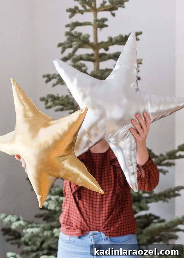Holding up metallic star pillows in front of a Christmas tree 