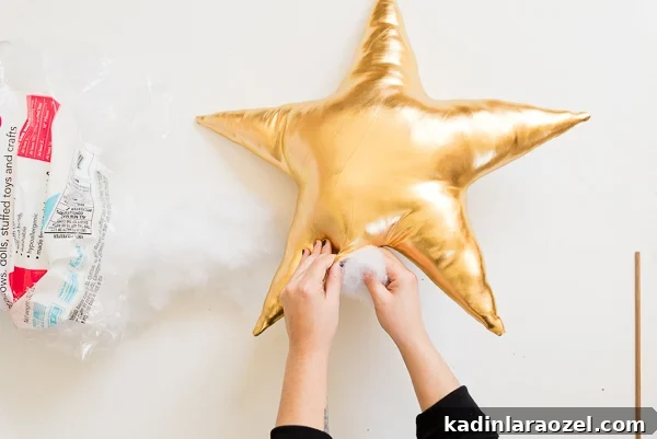 Stuffing gold DIY star pillow with poly-fil.