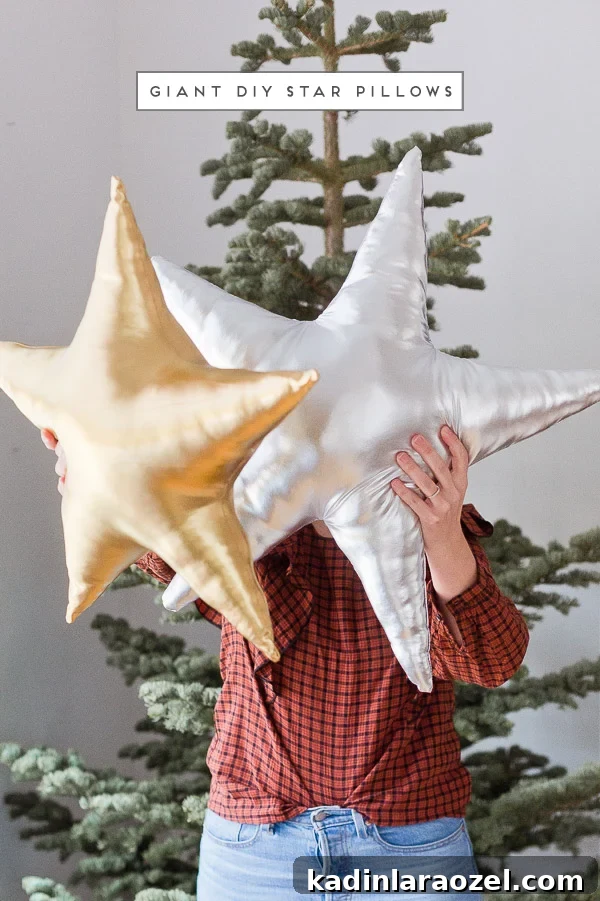 Woman holding giant star pillows in metallic silver and gold, in front of tree