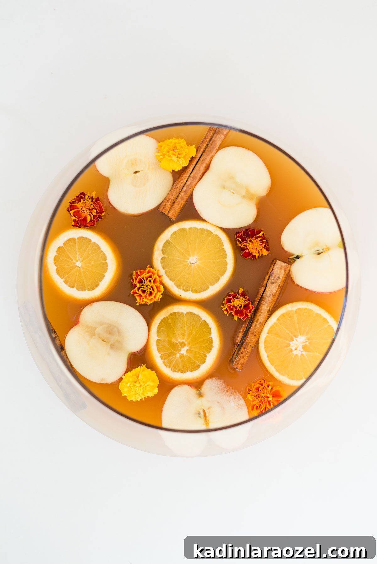 Apple cider punch recipe overhead on white table in glass punch bowl
