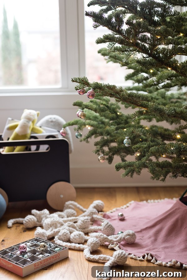 Pink DIY tree skirt with simple ornaments and a Scandinavian style Christmas tree