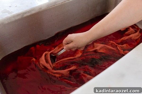 Dying simple canvas tree skirt with pink dye in a stainless steel sink