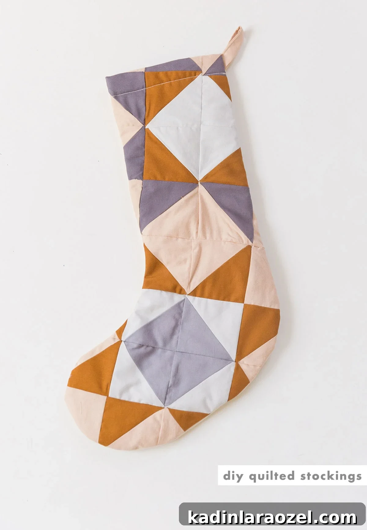Single quilted Christmas stocking in mustard yellow, lilac, and peach.